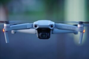 Close-up shot of Mavic Air 2 drone with propellers spinning, blurred background.